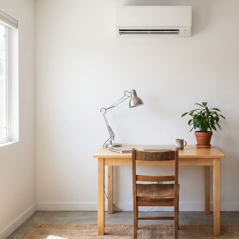 A ductless mini-split unit on the wall of a converted garage used as a home office